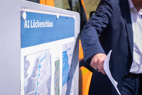 Gespräch neben einem Plakat zum Lückenschluss der A1 Gespräch neben einem Plakat zum Lückenschluss der A1