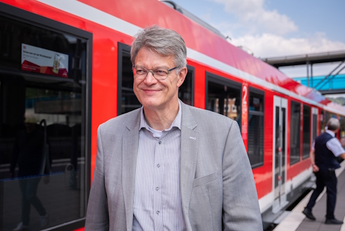 Patrick Schnieder geht an einem Bahnsteig entlang. Im Hintergrund steht eine Regionalbahn am Gleis. Patrick Schnieder geht an einem Bahnsteig entlang. Im Hintergrund steht eine Regionalbahn am Gleis.