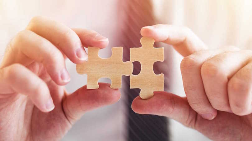 Zwei Hände setzen zwei Teile eines Puzzles zusammen. Zwei Hände setzen zwei Teile eines Puzzles zusammen.