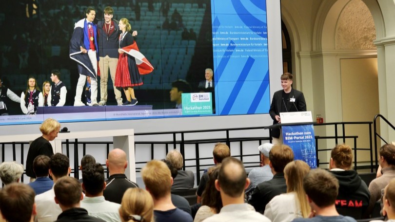 Ein Teilnehmer spricht am Rednerpult bei der Veranstaltung "Hackathon zum BIM-Portal 2025". Ein Teilnehmer spricht am Rednerpult bei der Veranstaltung "Hackathon zum BIM-Portal 2025".