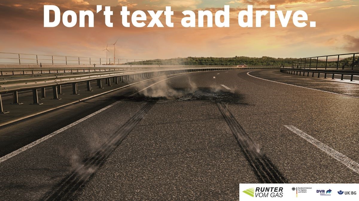 Autobahnplakat mit dem Text "Don't text and drive." Autobahnplakat mit dem Text "Don't text and drive."