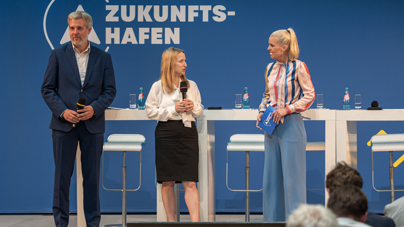 Frau Kluckert auf der Bühne zur Hafenstrategie mit zwei weiteren Redner Frau Kluckert auf der Bühne zur Hafenstrategie mit zwei weiteren Redner