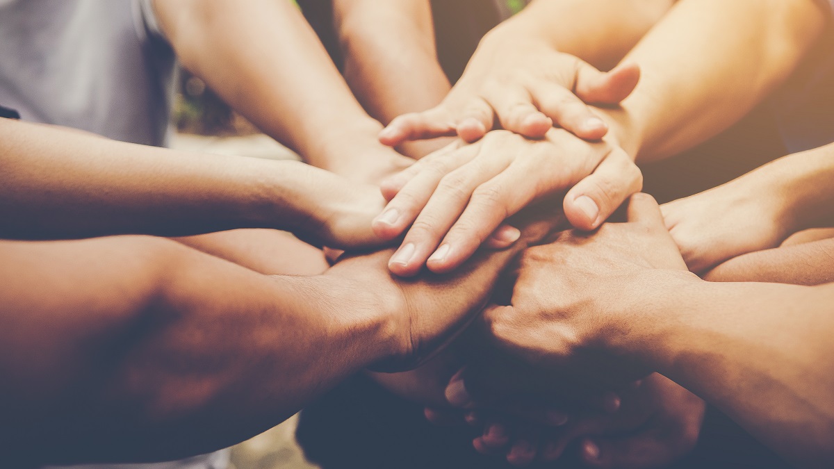 Several people join their hands together Several people join their hands together