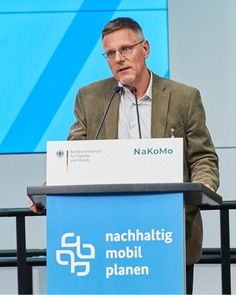 Dr. Wulf-Holger Arndt, Referent von der Technischen Universität Berlin, hält während der 6. NaKoMo-Jahreskonferenz einen Vortrag über nachhaltige Mobilität und integrierte Konzepte im ÖPNV.