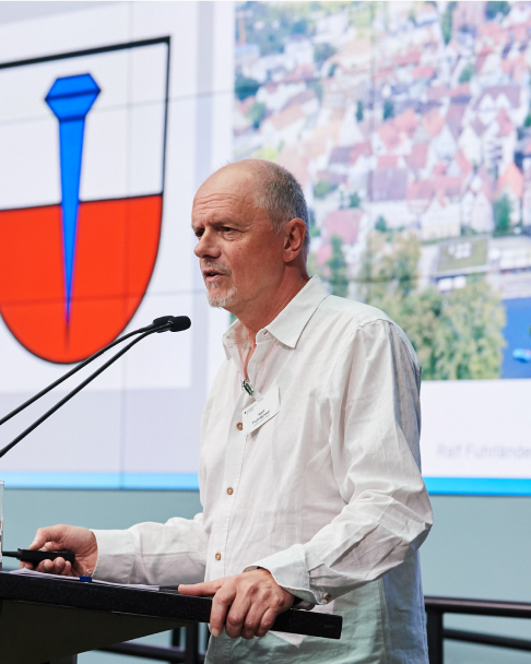 Ralf Fuhrländer, Referent der Stadt Nagold, spricht auf der 6. NaKoMo-Jahreskonferenz über den Aktionsplan für Mobilität und Klimaschutz in Nagold.